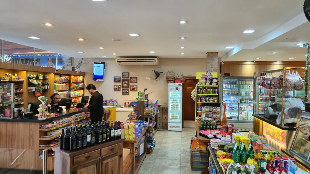Balcão de atendimento com caixa, adega de vinhos e geladeiras