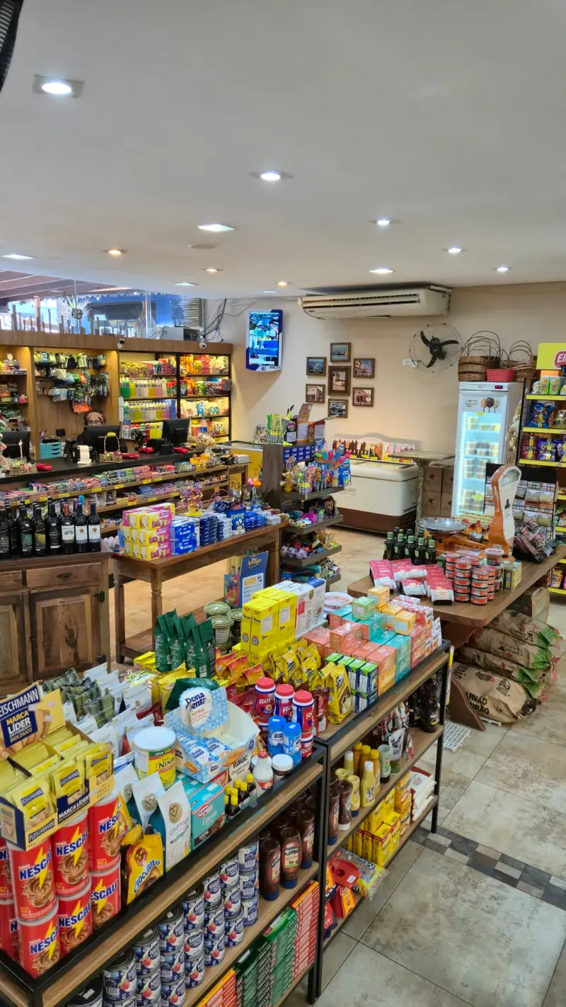 Empório com prateleiras de vinhos, biscoitos e produtos selecionados