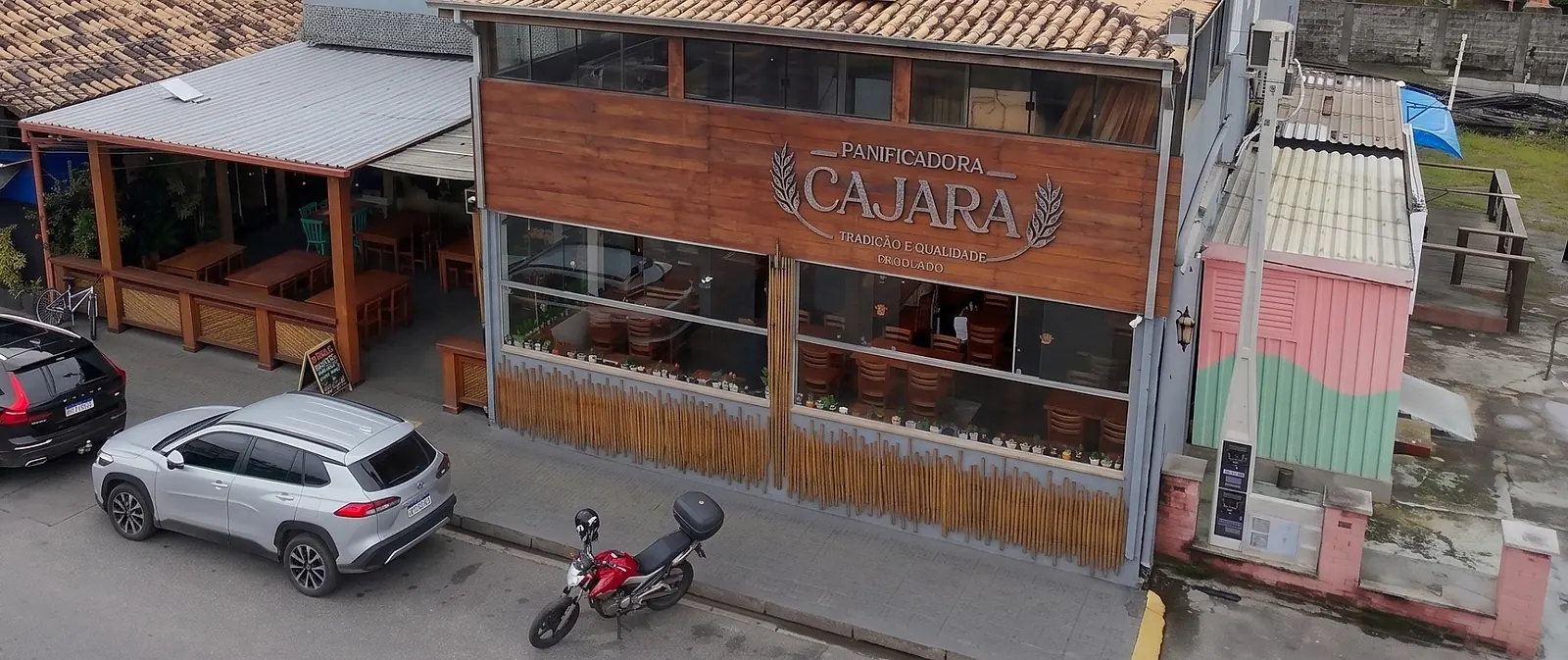 Fachada em madeira e bambu da Panificadora Cajara, com o letreiro da marca, na Av. Copacabana, em Ilha Comprida